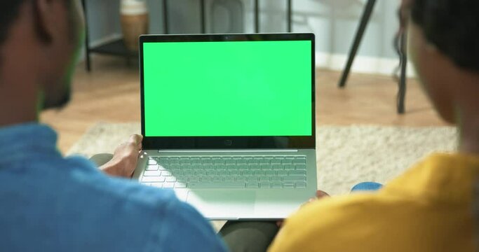 Close Up Of Couple Videochatting Online On Laptop With Chroma Key Sitting At Home. Over Shoulder View Of African American Man And Woman Speaking On Video Call On Computer With Green Screen