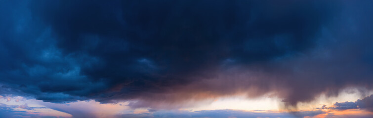 Fototapeta na wymiar Dramatic sky with dark rainy clouds at sunset.