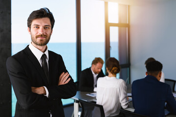 Confident businessman in office with his teamwork. Concept of cooperation