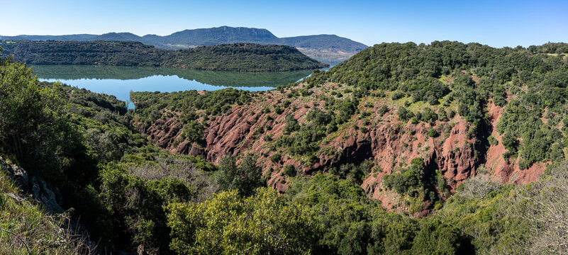 Panorama sur un canyon de terre rouge avec un lac en arrière plan