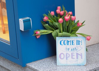 Pink tulips and come in - we are open sign 