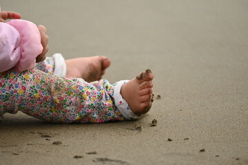 Child with a barefoot full of sand playing at the beach having fun