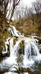 Fototapeta na wymiar Frozen waterfall in the mountain Zlatibor in Serbia. Waterfall in winter season.