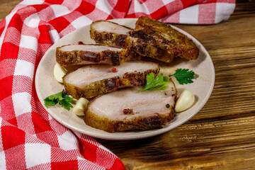 Baked pork belly in a plate on wooden table