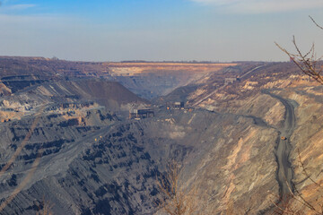 Fototapeta na wymiar Huge iron ore quarry with working dump trucks and excavators