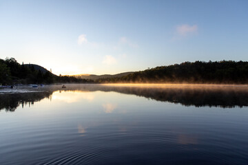 Fototapeta na wymiar vue d'un cygne gonflable qui flotte sur un lac calme lors d'un lever de soleil