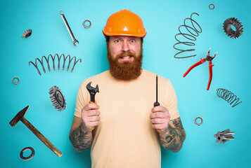 Confused man with screwdriver and spanners. worried and uncertain expression. cyan background