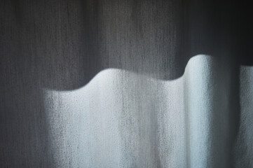white pleated curtain with one side exposed to the sun and the o
