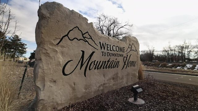 Moving in to the Welcome to Downtown Mountain Home sign in Idaho as a car drives by.