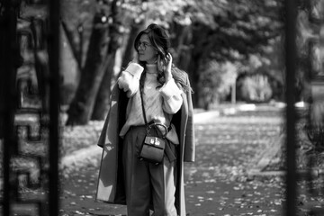 Fototapeta premium beautiful young woman in beret and coat walks in the autumn city