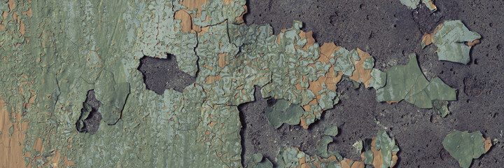 Peeling paint on the wall. Panorama of a concrete wall with old cracked flaking paint. Weathered rough painted surface with patterns of cracks and peeling. Wide panoramic grunge texture for background
