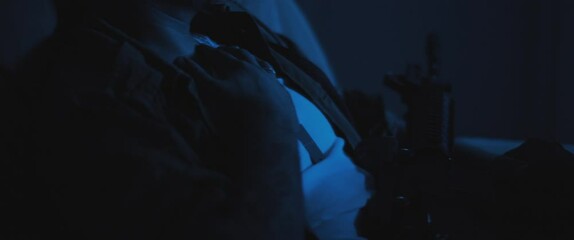 A depressed soldier sitting in chair with rifle, dealing with post trauma.