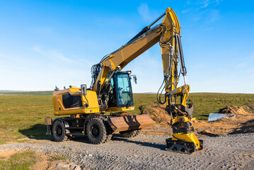 Fototapeta na wymiar Wheeled excavator in a road contruction site in the countryside of Iceland at sunset in summer