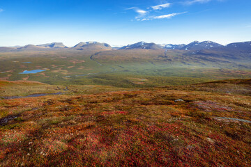 Lapponian gate, famous mountain pass in the Swedish arctic in beautiful autumn colors on a sunny day. Viewed from Nuolja, Njulla mountain. Hiking in Abisko national park, Kiruna, Sweden.