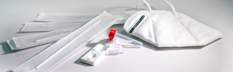 Covid-19 rapid antigen self test for diagnostic at home and a ffp-2 mask on a light gray...