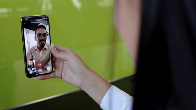 Detalle mano de mujer en videollamada con amigo
