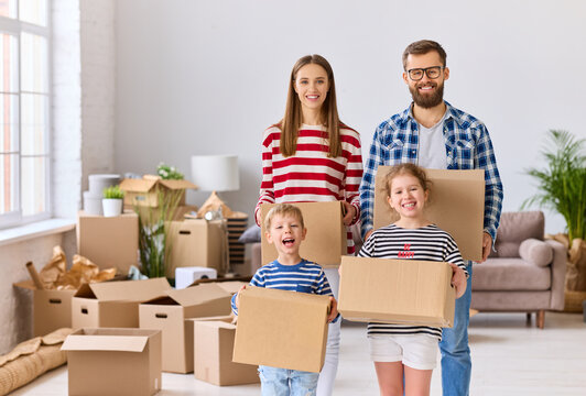 Positive family standing in room in new flat