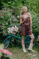 Elegant young woman close her eyes hold peony flower in summer garden, dreamy mood