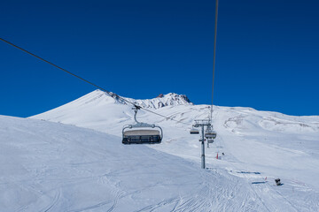 Fototapeta na wymiar ERCIYES, TURKEY - FEBRUARY 2021: View of the ski slopes and chair lifts at Mount Erciyes ski area, February 2021, in Kayseri, Turkey. Mount Erciyes ski area is one of the longest slope in Turkey