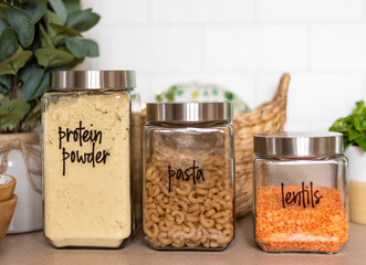 Closeup of neatly organized kitchen pantry with labeled glass canisters