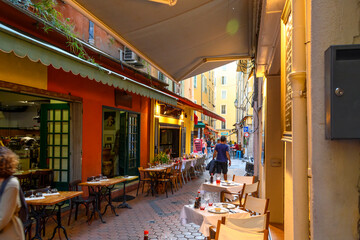 Uitzicht op een van de vele smalle steegjes vol met cafés en winkels in de historische oude binnenstad van Vieux Nice, Frankrijk, aan de Franse Rivièra.