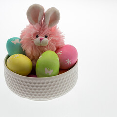 Easter themed still life with pink plush bunny and hand dyed easter eggs.
