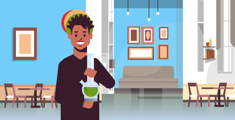 african american guy smoking cannabis marijuana with bong drug consumption concept modern coffeeshop interior portrait horizontal