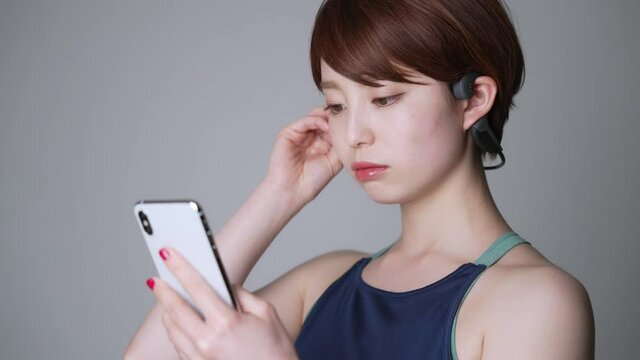スマホで音楽を聴く女性