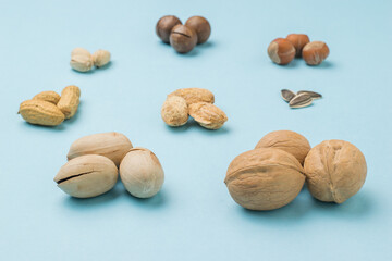 Different types of nuts arranged in three pieces on a blue background.