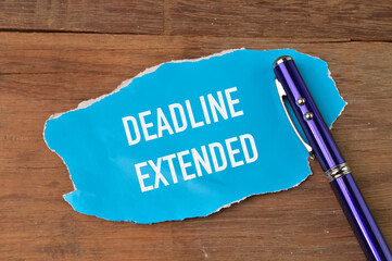 Top view of pen and torn paper written with DEADLINE EXTENDED