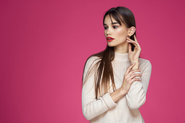 Woman with red lips bright makeup white blouse long hair pink background