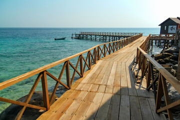 Wooden bridge pier along the seashore with turquoise water