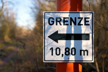 Fototapeta premium Schild mit der Aufschrift Grenze 10,80 Meter an einem Wanderweg in einem Wald in Deutschland