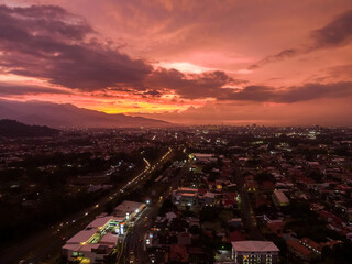 Naklejka premium Beautiful aerial view of a pink and red sunset in the city of San Jose Costa Rica