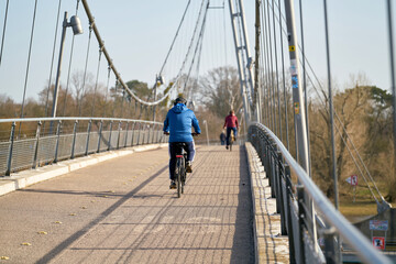 Fahrradfahrer auf der Hängebrücke Herrenkrugsteg auf dem Weg über die Elbe zum Herrenkrugpark im Norden von Magdeburg