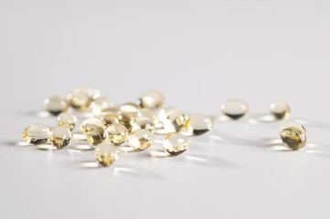 Vitamin D in the form of yellow capsules on a white background