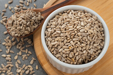 Bowl with sunflower seeds. Detail of wooden spoon and bamboo support.