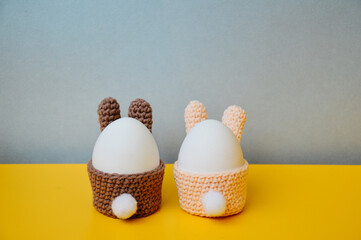 Easter holiday preparation. Crocheted egg basket in the shape of an Easter bunny. Egg stand in the...