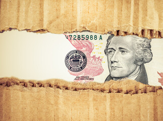 Hamilton $10 bill through ripped cardboard