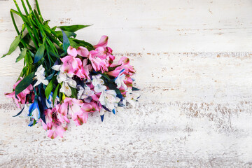 Beautiful bouquet of pink and blue alstroemerias on wooden background.