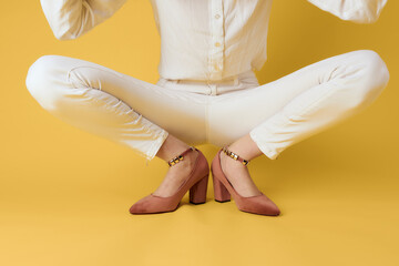 Female legs white pants fashionable clothes shoes luxury yellow background