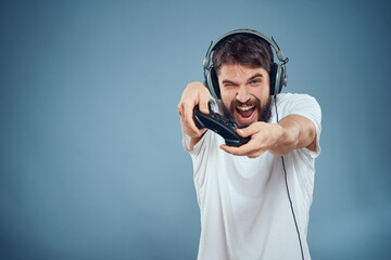 a man in a white t-shirt with a joystick in his hands game console entertainment emotions © SHOTPRIME STUDIO