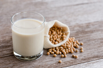 Glass of soy milk isolated on wooden table background. 