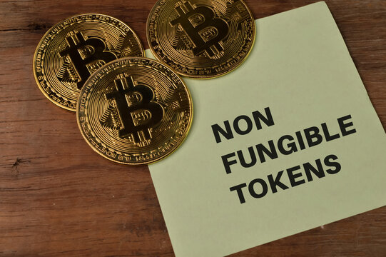 Golden bitcoins and memo note written with NON FUNGIBLE TOKENS