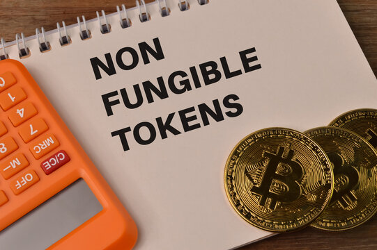 Calculator, golden bitcoins and notebook written with NON FUNGIBLE TOKENS