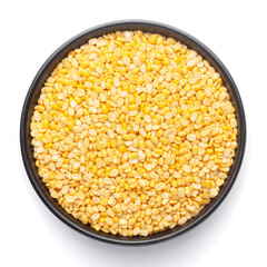 Macro Close up of Organic yellow Gram (Vigna radiata) or split yellow moong dal on a ceramic black bowl. Top view 