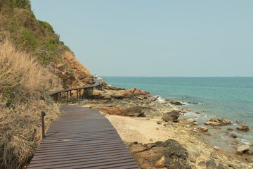 Obraz premium Rocks on the beach are rocks and brown wooden bridges along the hillsides, rocky mountains and sea close to island, eco-tourism concept