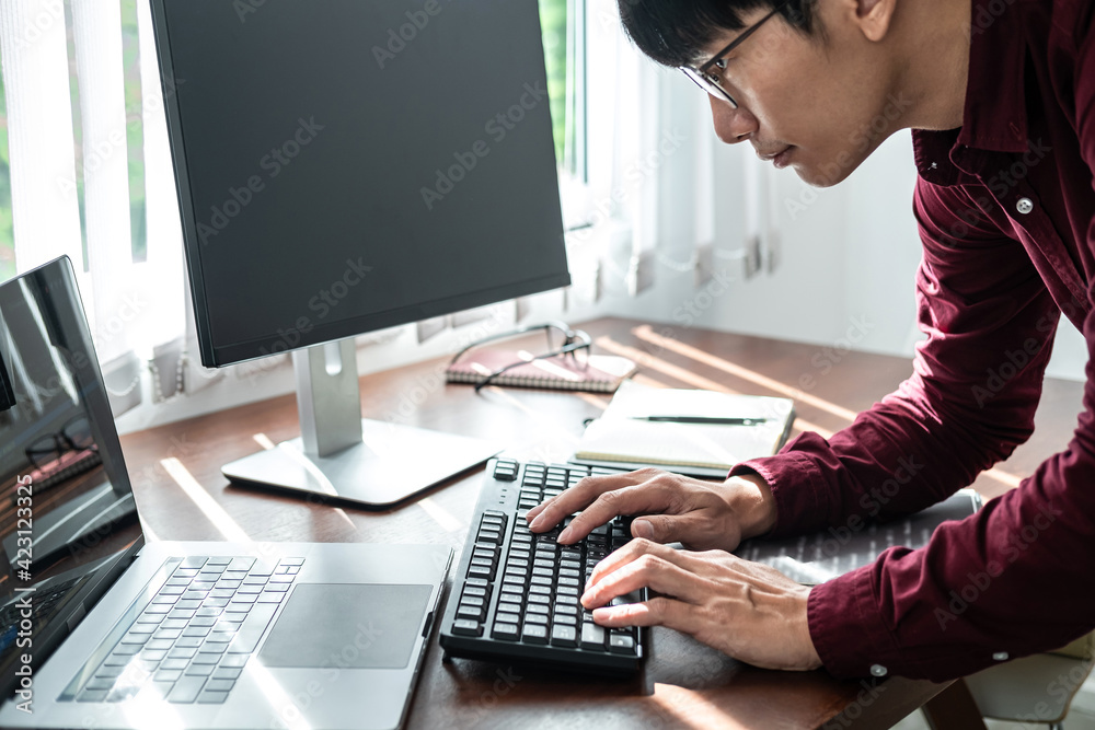 Poster Asian man programmer looking on screen laptop to typing code data with keyboard about website and applications