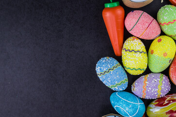 Colorful Easter eggs and other objects on a trendy black background.
