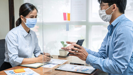 Asian business man showing investment amount on calculator to partner and discussion about new project